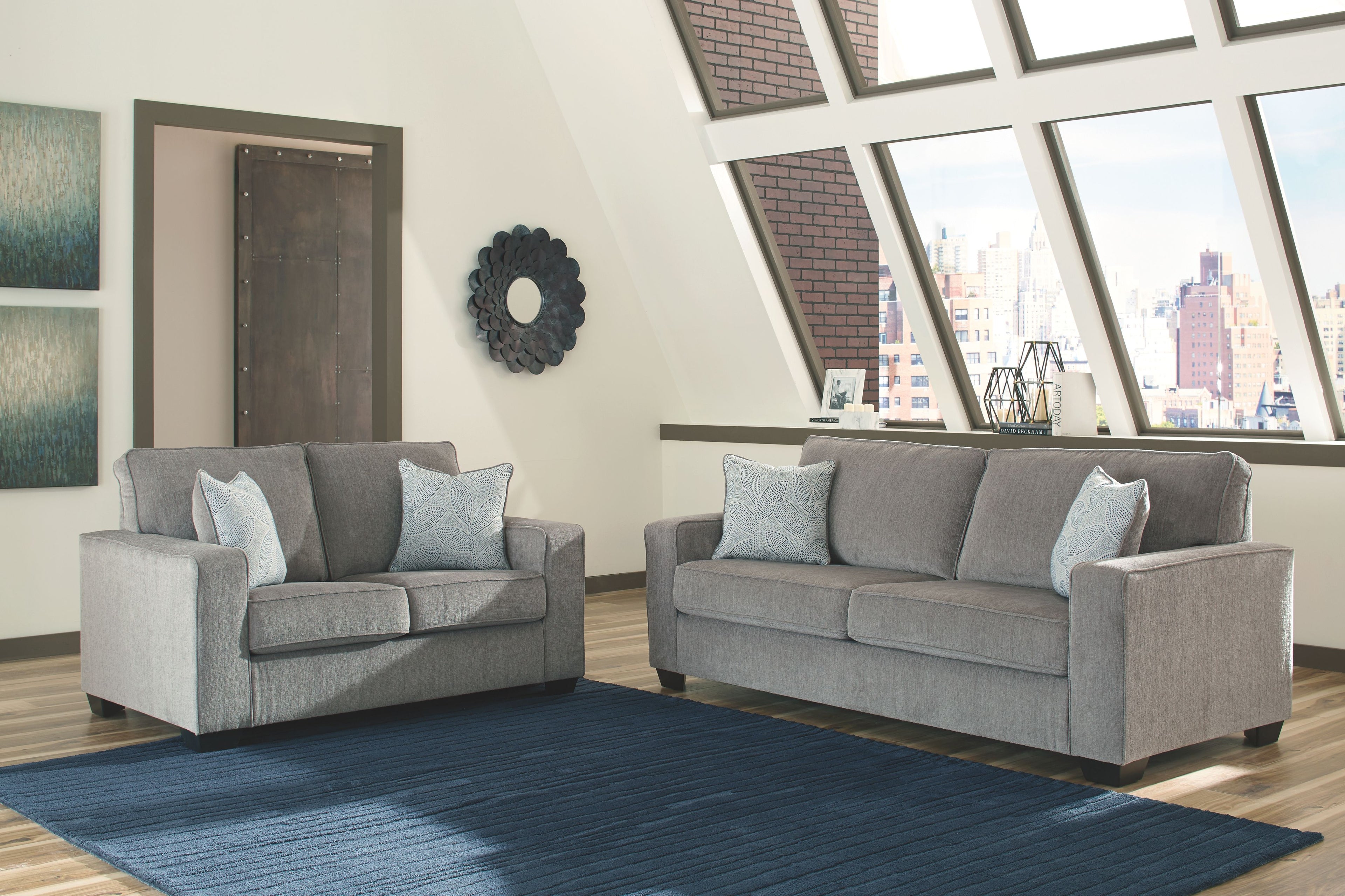 Gray fabric sofa and loveseat with light blue accent pillows