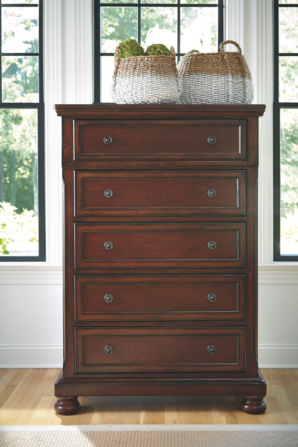 Rustic brown chest of drawers with four drawers and two woven baskets on top