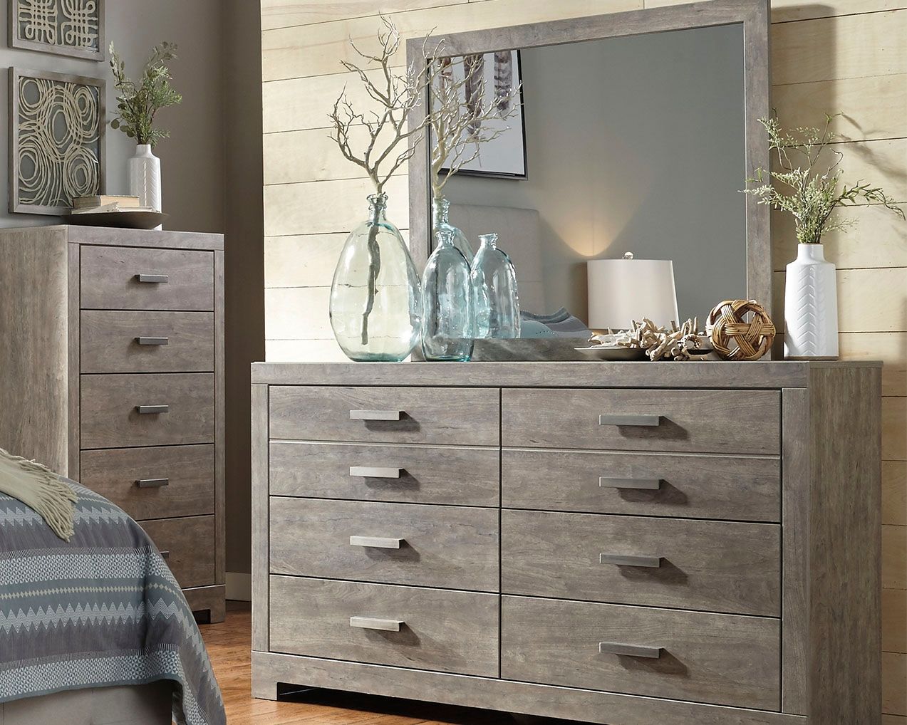 Gray dresser with mirror top and six drawers featuring brushed metal bar pulls.