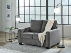 Dark gray sofa set with matching armchair, topped with throws