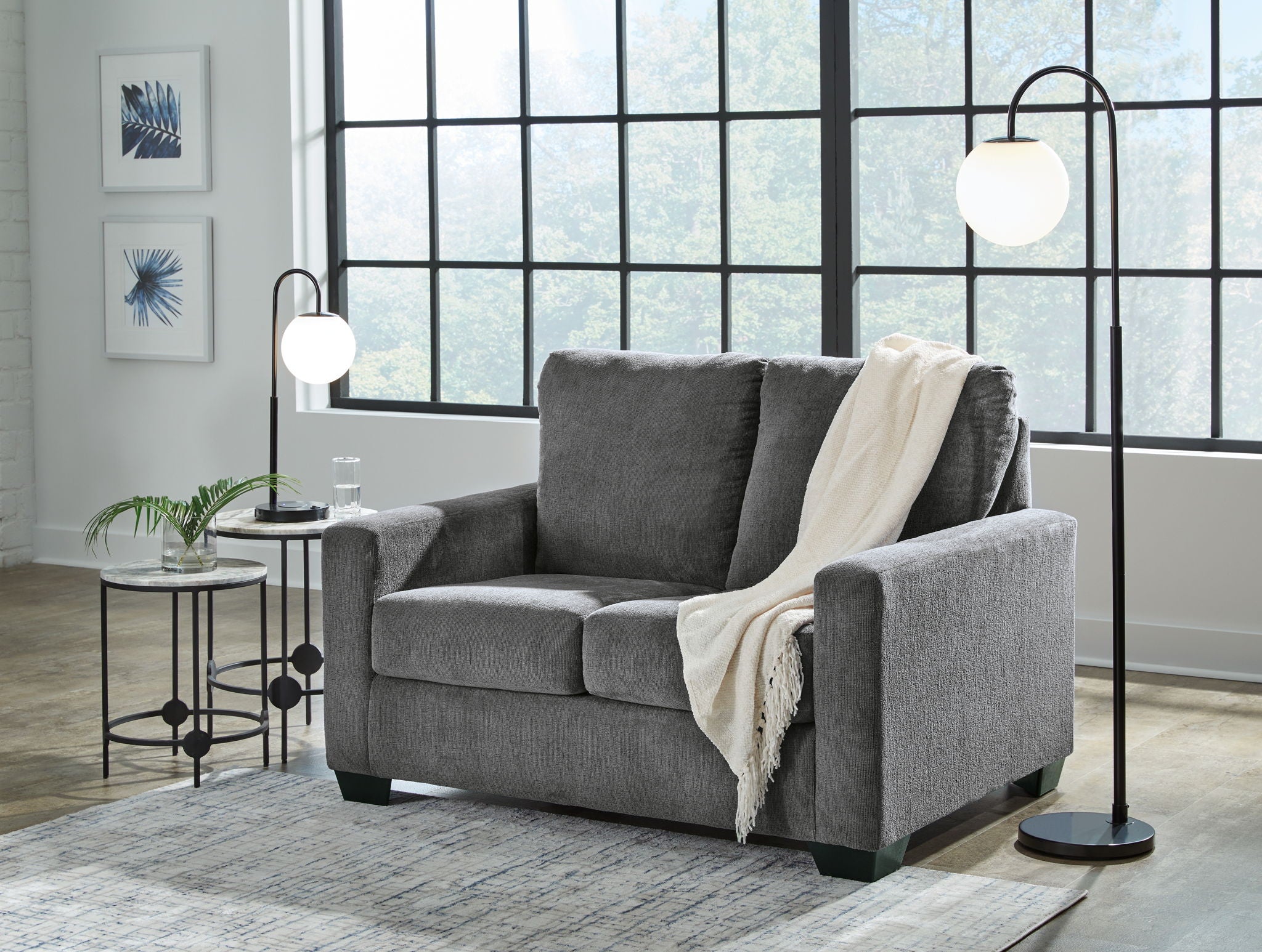 Dark gray sofa set with matching armchair, topped with throws