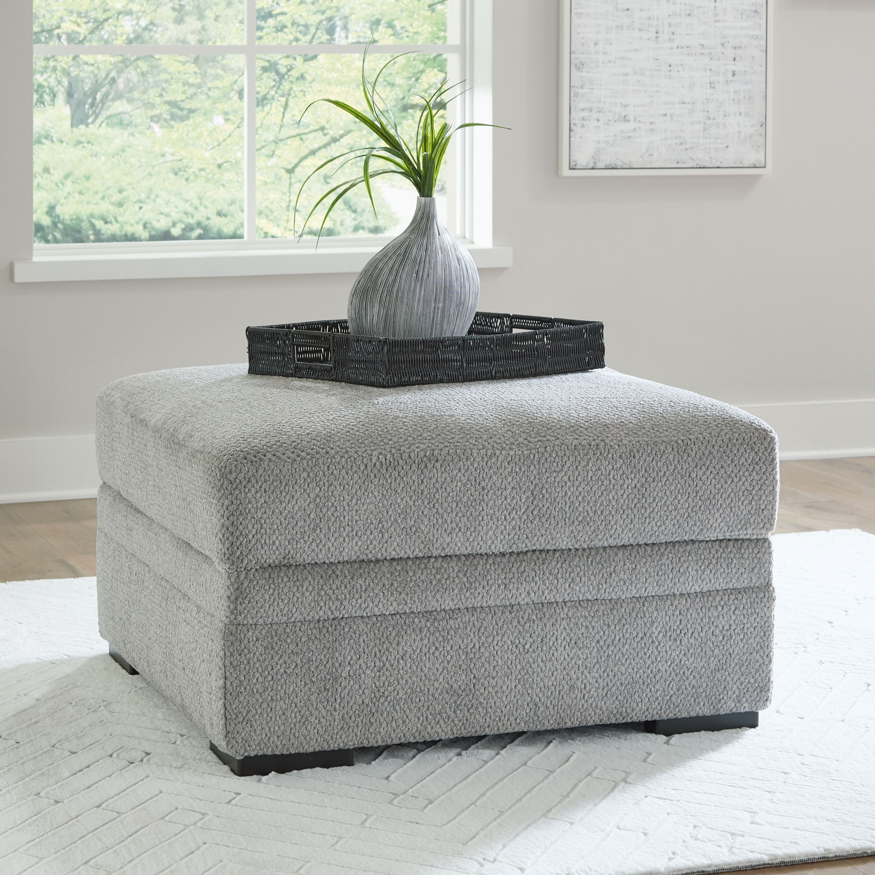 Cement gray upholstered storage ottoman with square top and black legs