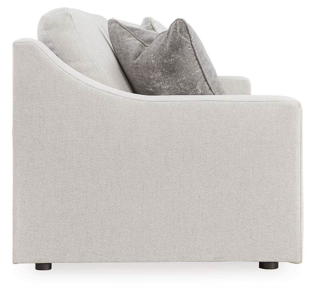 Light gray sofa with boxy arms, dark legs, and stacked gray pillows