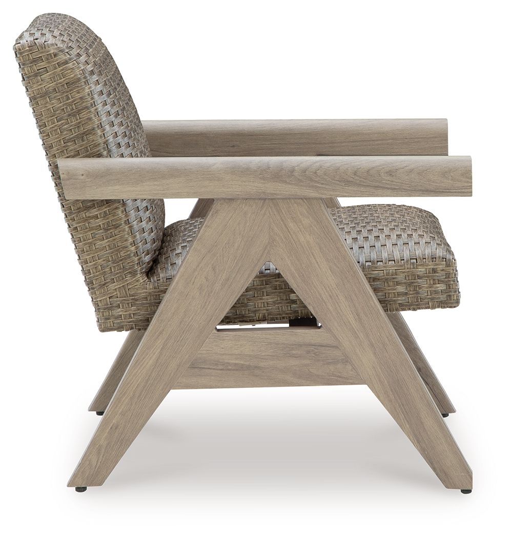 Beige woven rocking lounge chair with curved back and X-frame wooden rockers