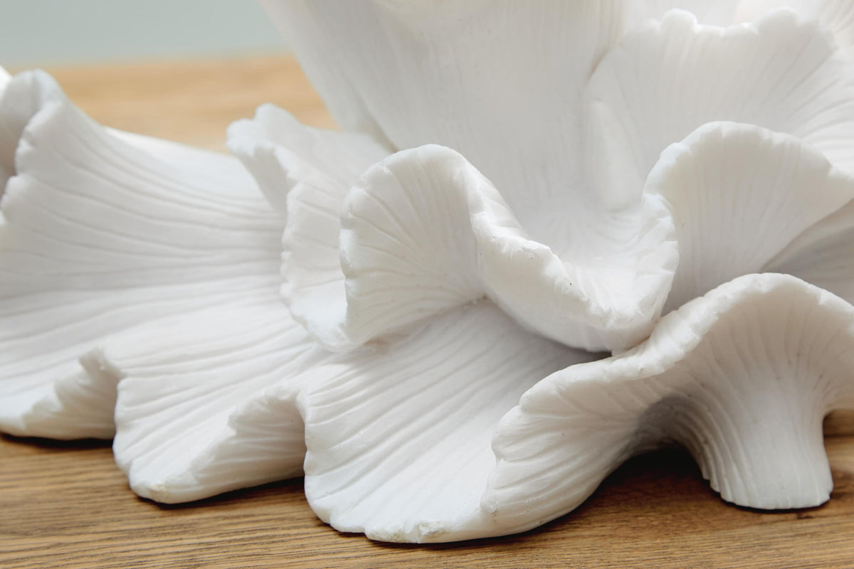 Close-up of white sculpture with textured, ribbed petal surfaces and curled tips