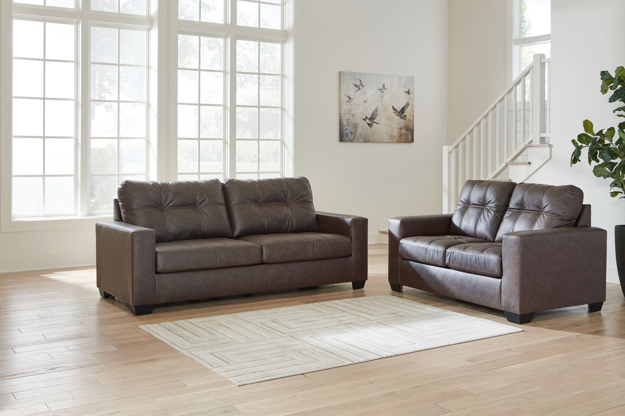 Dark brown leather-look loveseat and recliner chairs with tufted backs and track arms