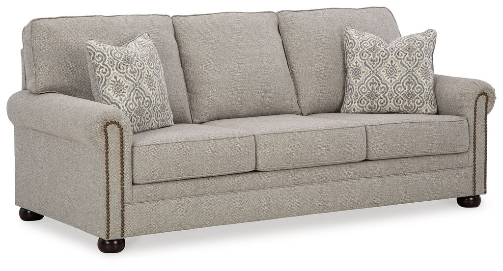 Queen sofa sleeper with light gray upholstery, three seat cushions, and two patterned pillows