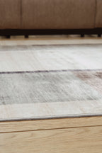 Beige & gray abstract washable rug laid flat with stitched edge trim