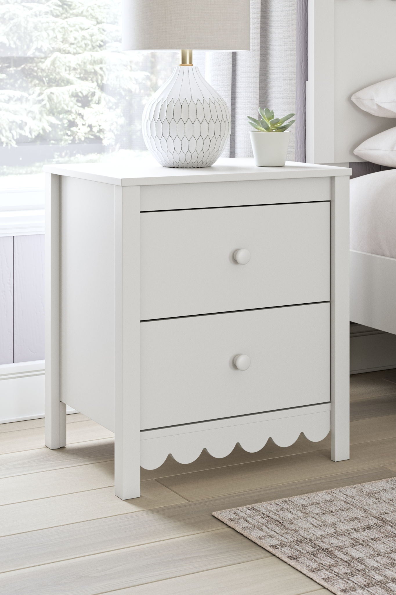 White two-drawer nightstand with scalloped bottom and round drawer knobs