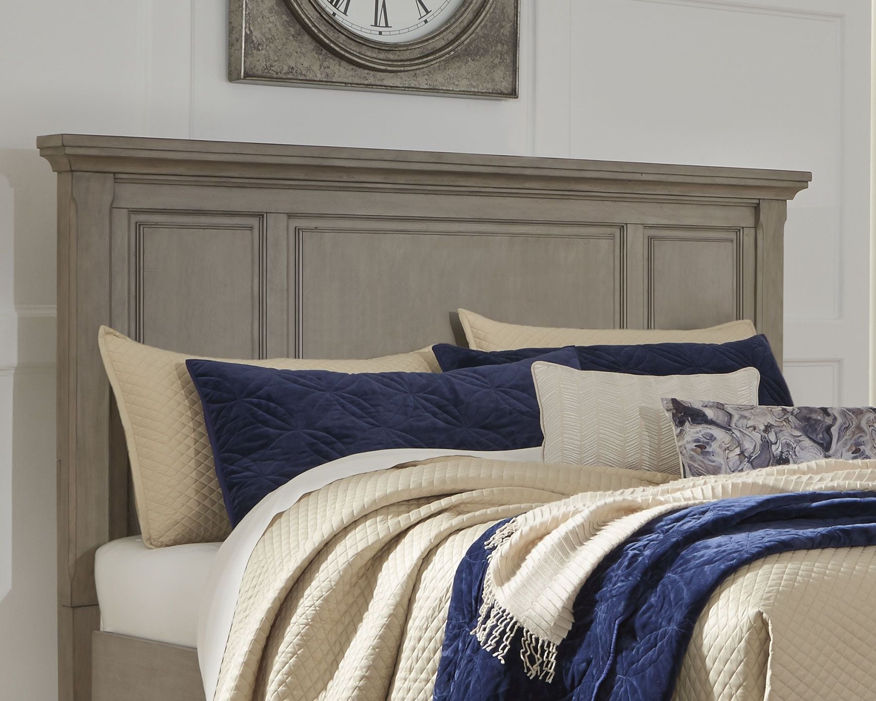 Gray panel headboard with recessed rectangular panels behind bed pillows