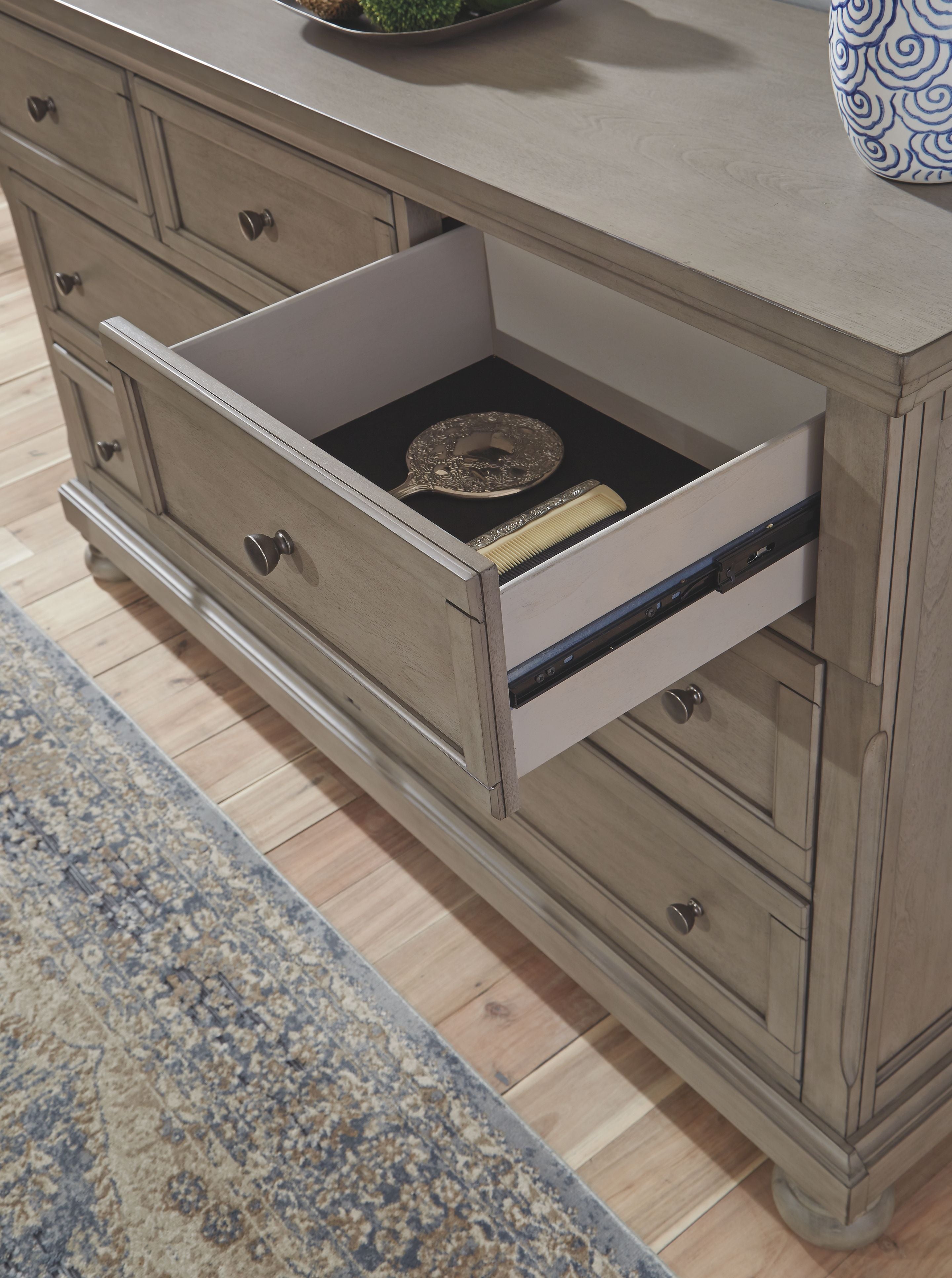 Light gray Lettner dresser with one drawer open, showing storage space