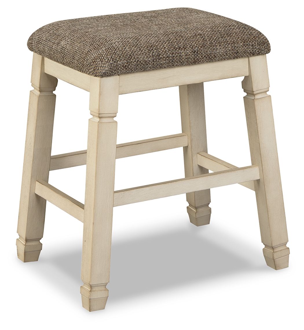 Upholstered stool with textured neutral fabric seat and light wood turned legs, footrest