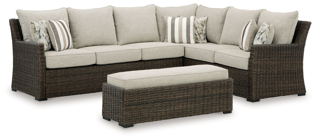 Brown wicker sectional sofa set with beige cushions and striped throw pillows