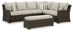 Brown wicker sectional sofa set with beige cushions and striped throw pillows