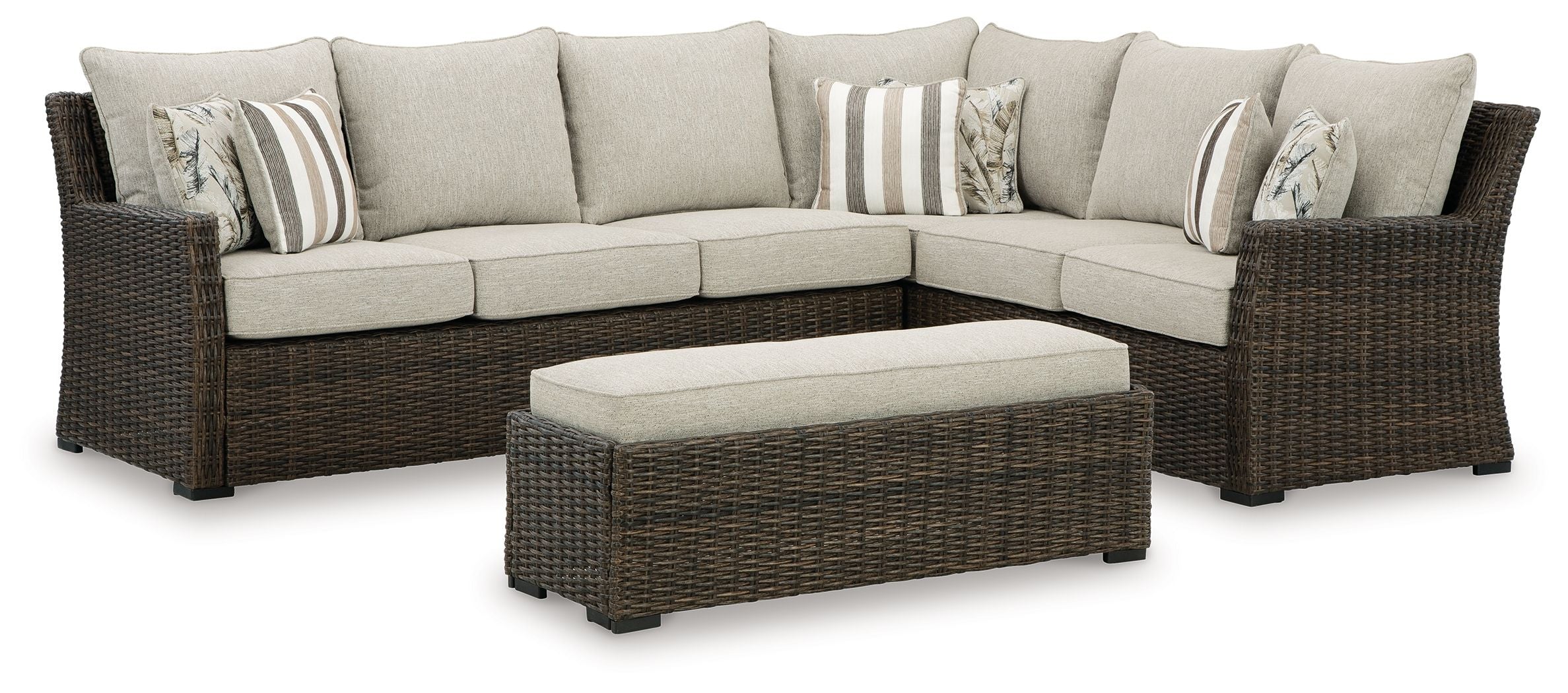 Brown wicker sectional sofa set with beige cushions and striped throw pillows
