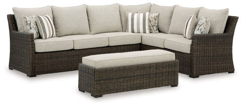 Brown wicker sectional sofa set with beige cushions and striped throw pillows