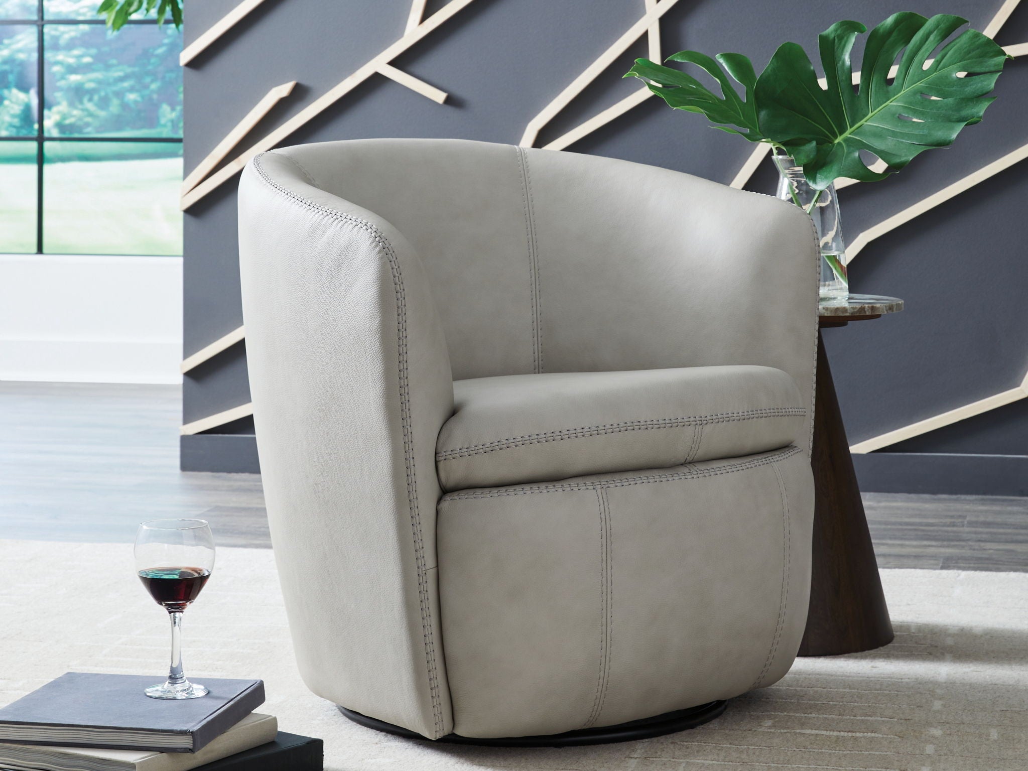 Light beige upholstered swivel chair with rounded arms and contoured base
