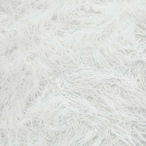 White shaggy faux fur upholstery texture on an oversized rounded ottoman
