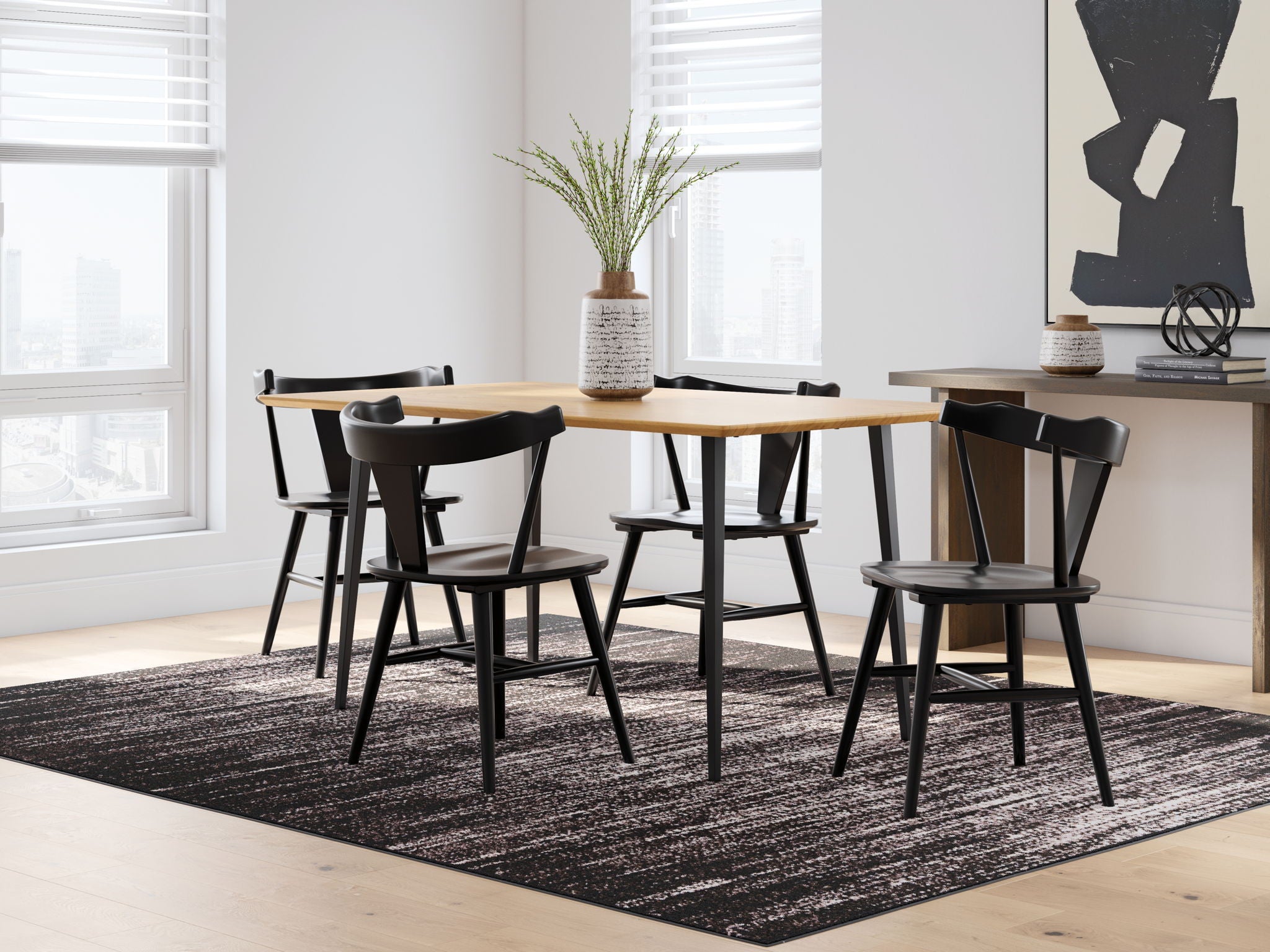 Light brown dining table with four black chairs and matching legs