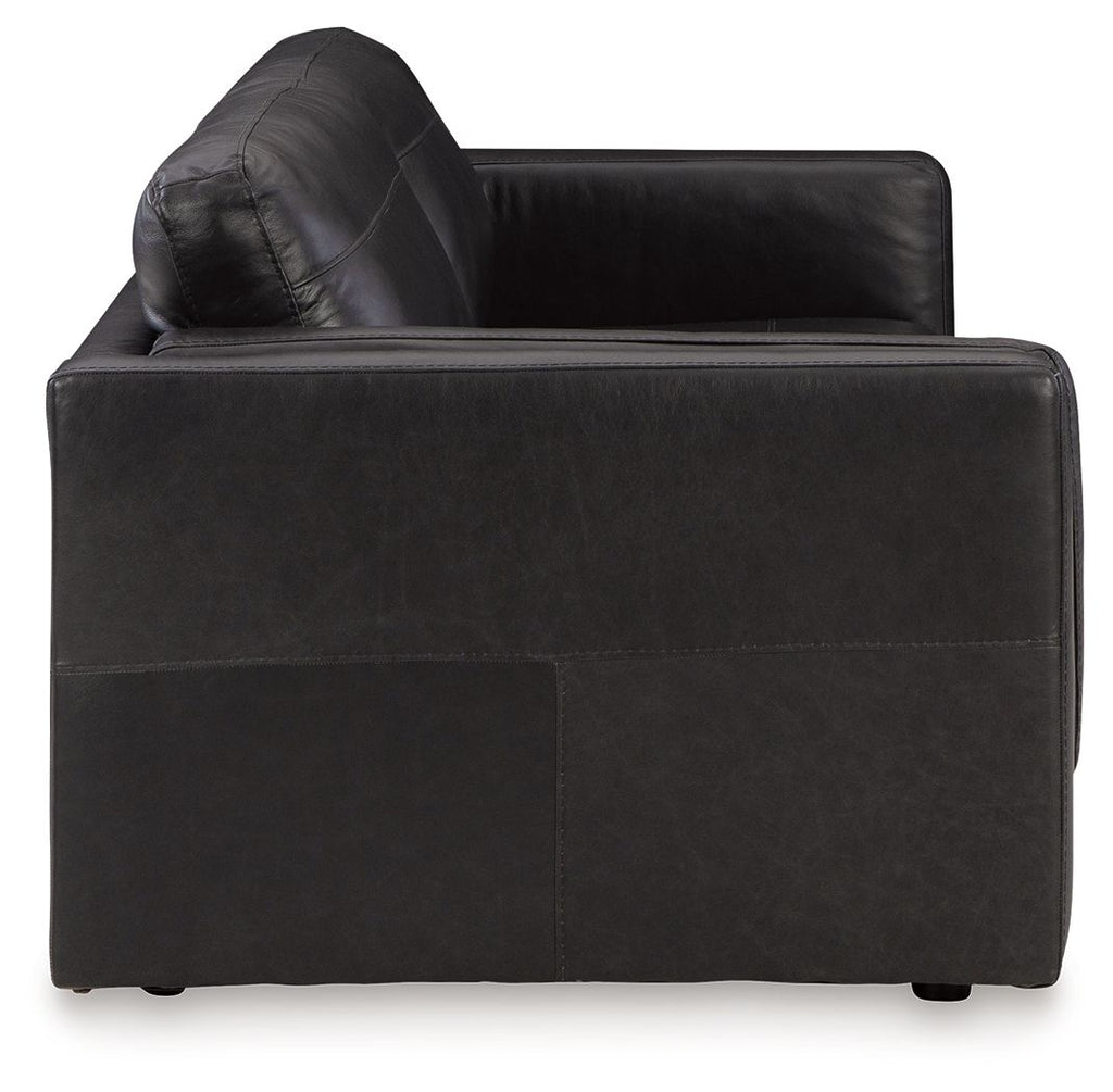 Dark leather sofa corner with tufted backrest and padded arms