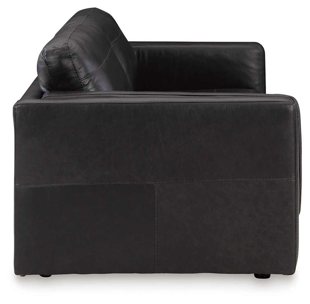 Dark leather sofa corner with tufted backrest and padded arms