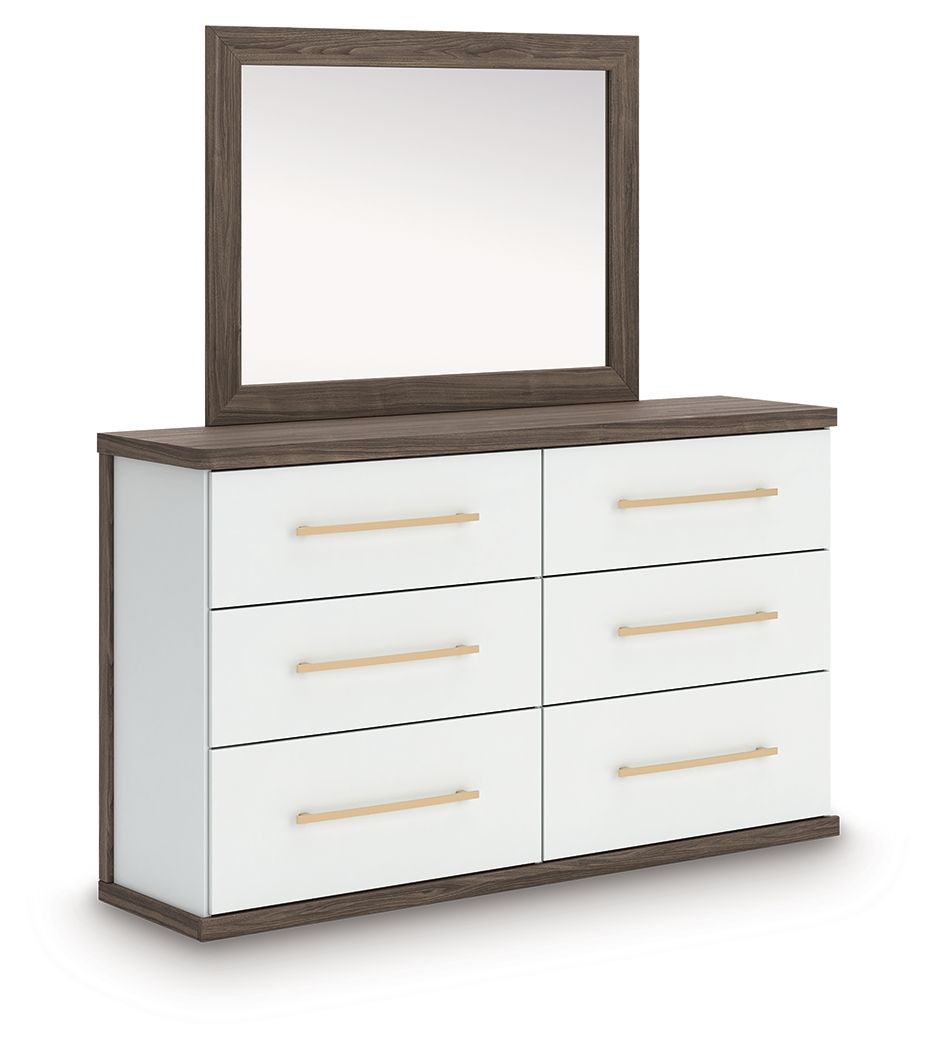 Six-drawer dresser with matching mirror, white drawers, warm wood frame and gold bar pulls.