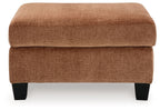 Clay fabric ottoman with rounded seat cushion and dark wooden legs