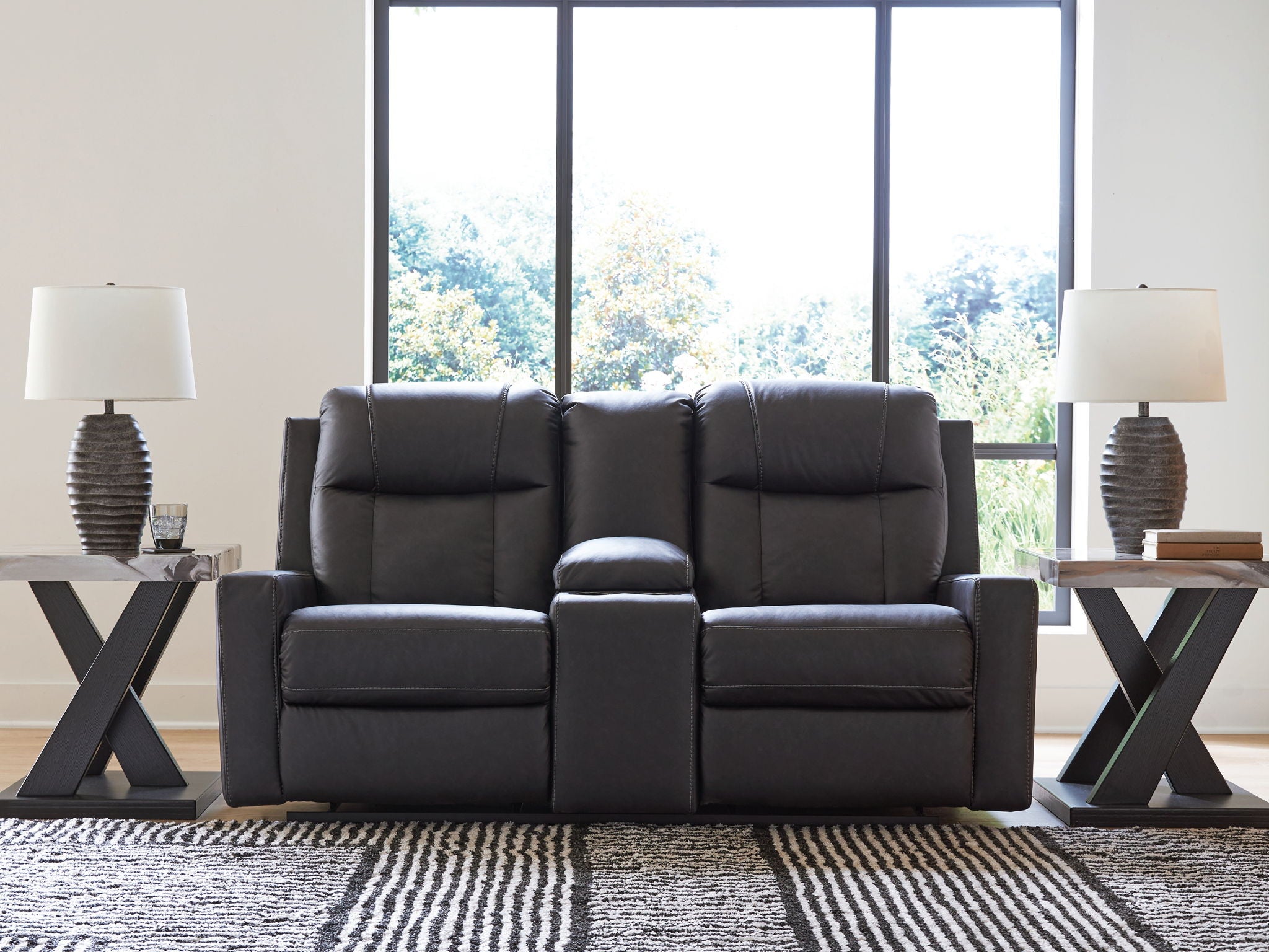 Black double reclining loveseat with center console and plush headrests for lounging