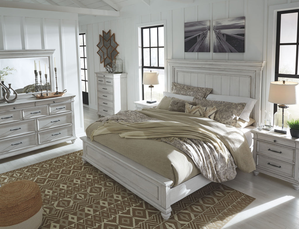 Panel bed with white headboard and beige bedding with gray throw pillows