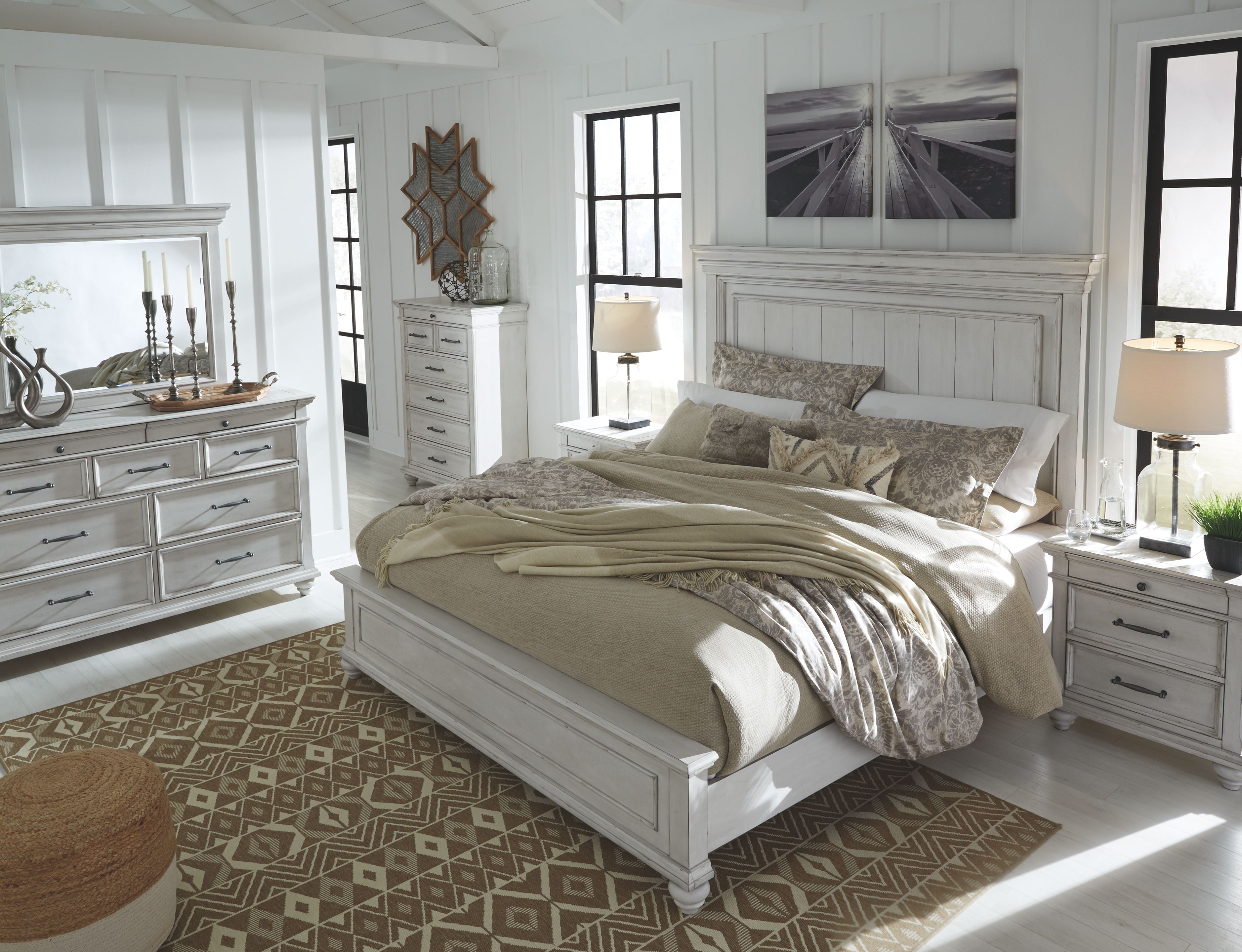 Panel bed with white headboard and beige bedding with gray throw pillows