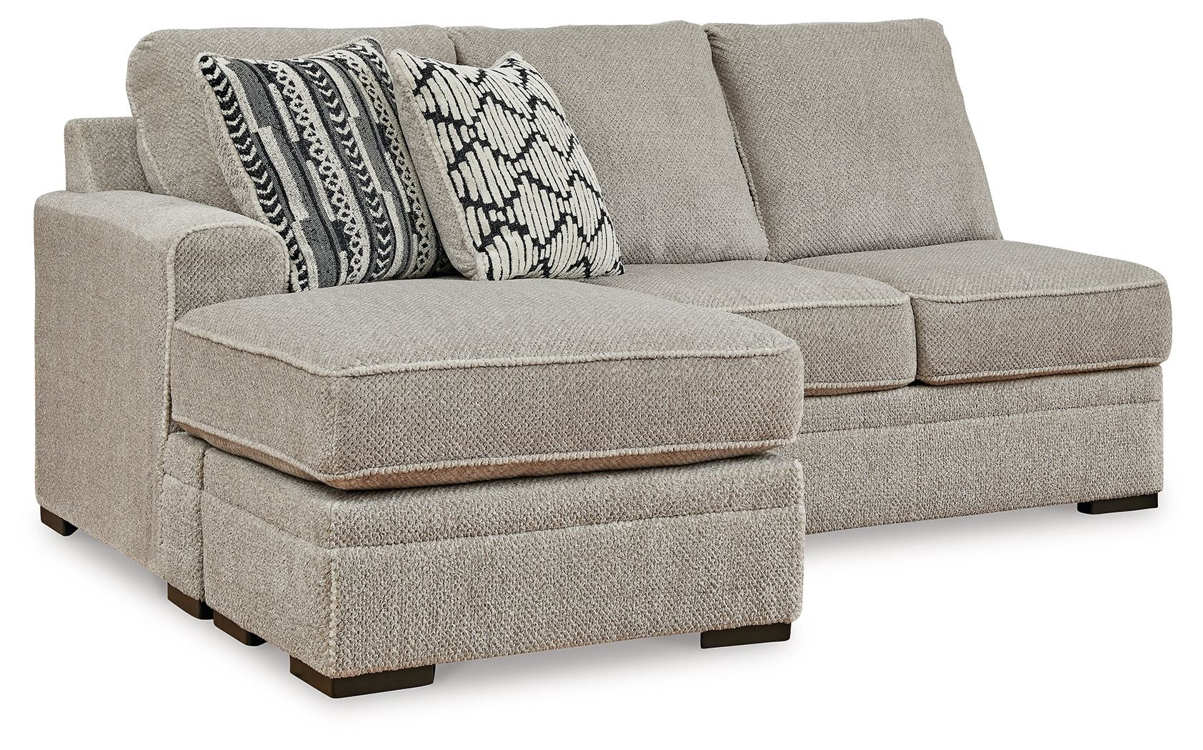 Light gray fabric sofa chaise with square arm and two patterned throw pillows