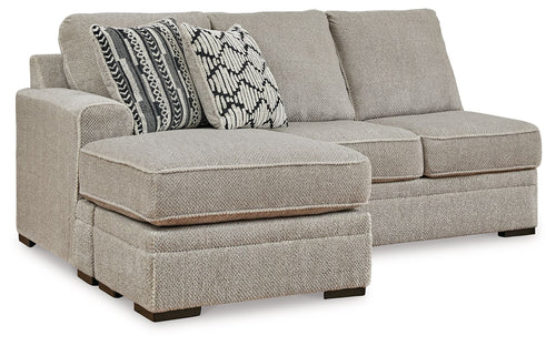 Light gray fabric sofa chaise with square arm and two patterned throw pillows