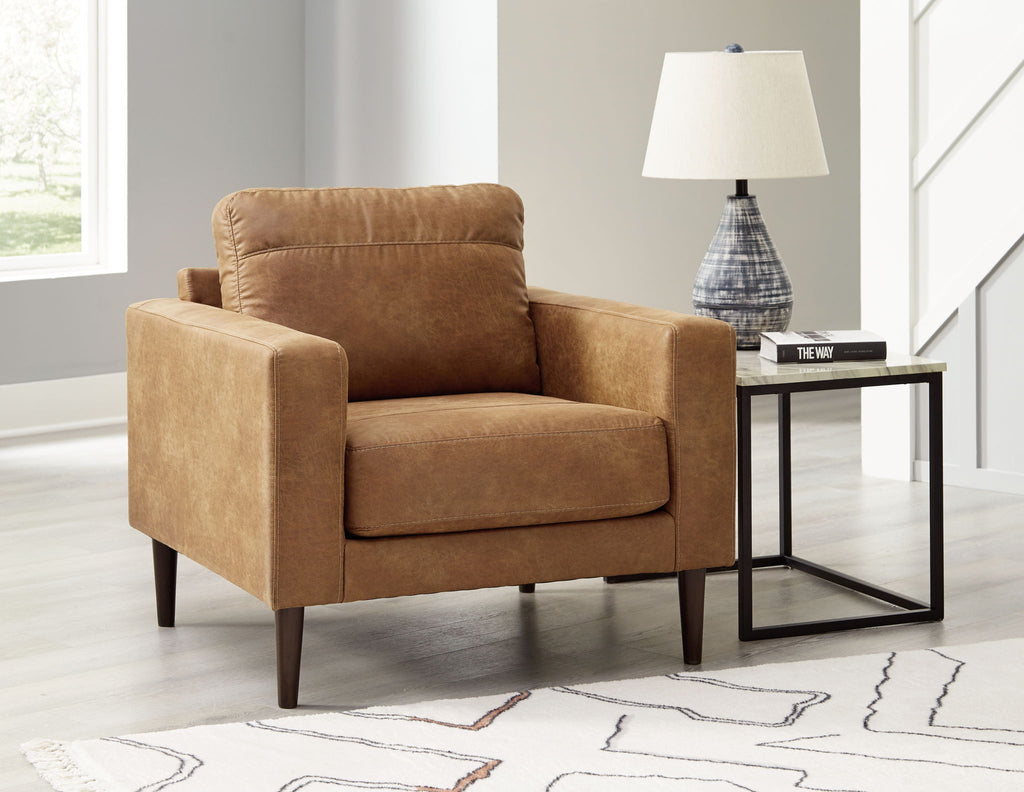 Light brown upholstered armchair with matching ottoman and padded backrest
