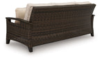 Dark brown wicker sofa with light gray cushions, shown from the side
