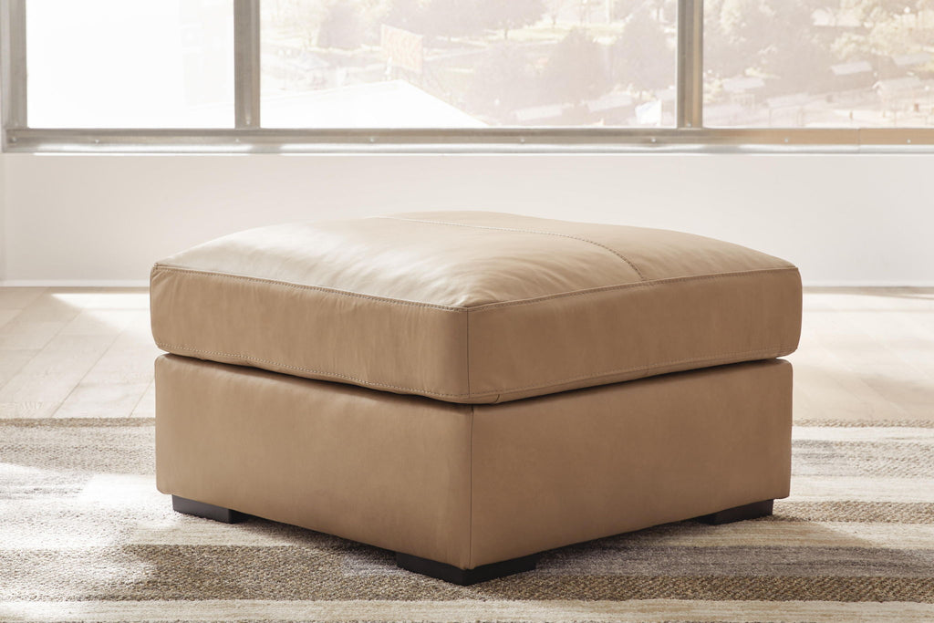 Toffee leather-look ottoman with padded square top and low tapered base