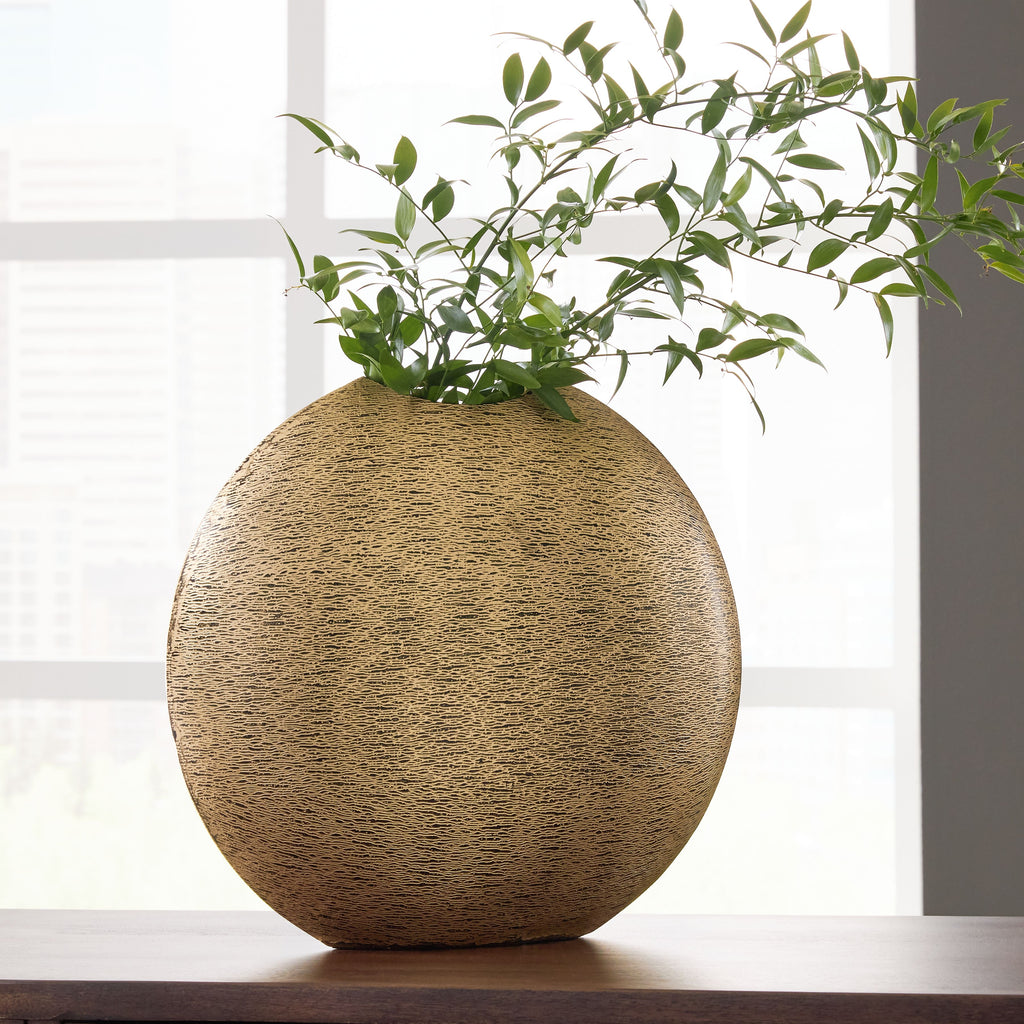 Gold textured vase with rounded teardrop shape and green stems inside