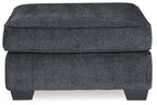 Dark gray upholstered accent ottoman with padded lid and visible front panel seams