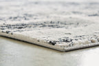 Black and gray rug with textured pile and fringe edge detail