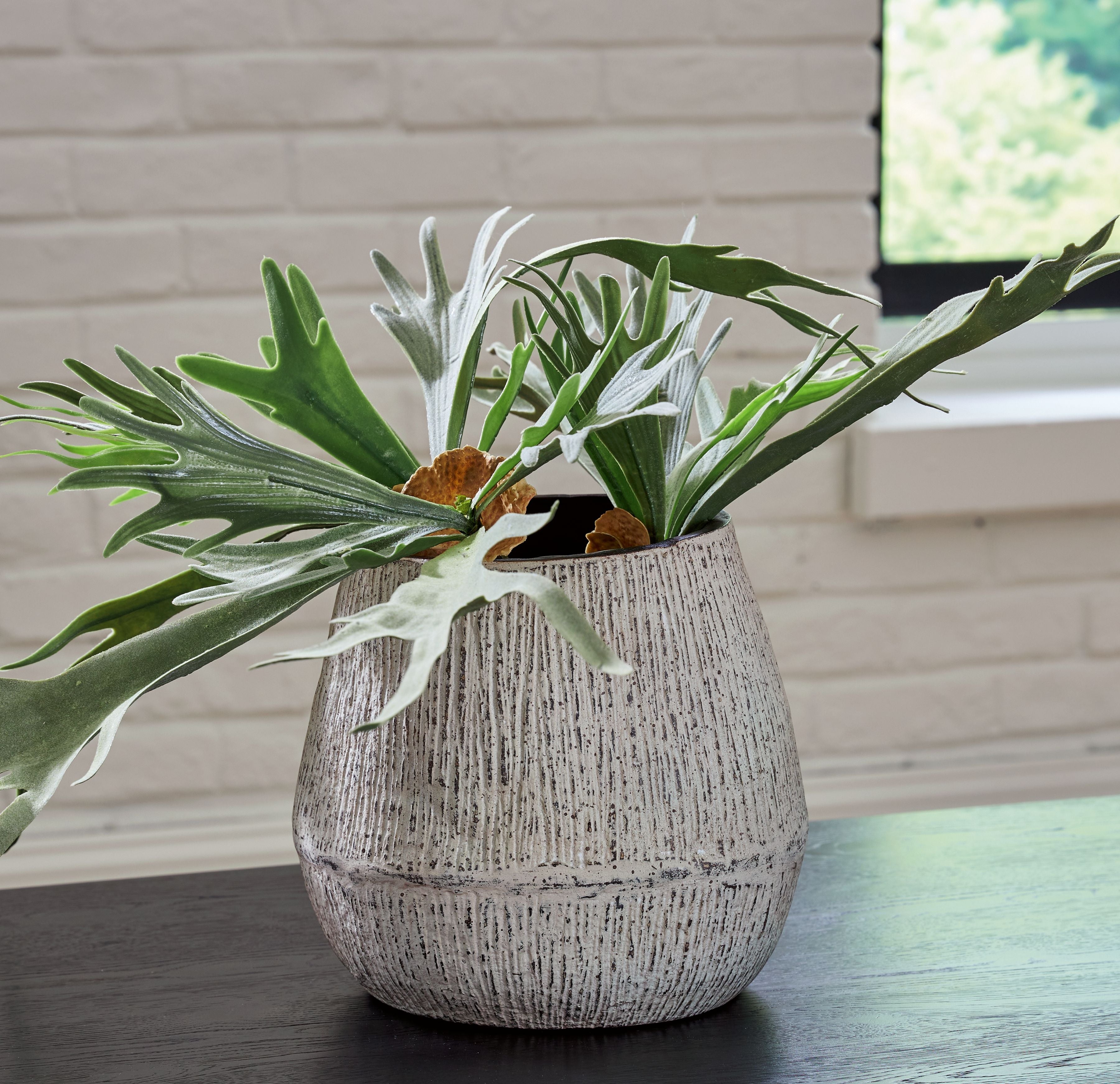 Ceramic vase with green stems, dark interior rim, and speckled light gray ceramic finish