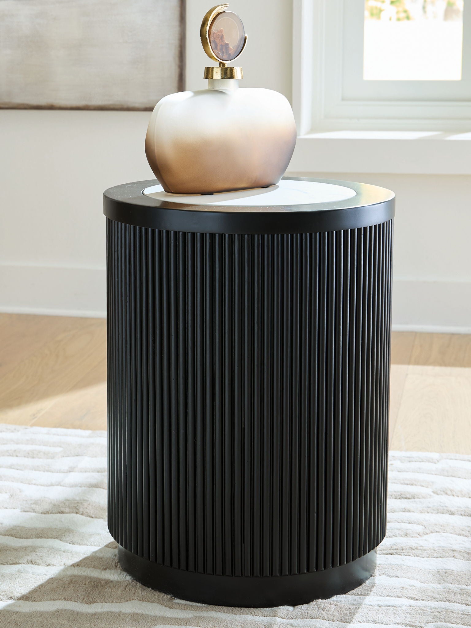 Black ribbed round table with white marble-look top and dark outer rim