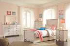 Nightstand with drawers, dark metal pulls, and turned legs beside the bed