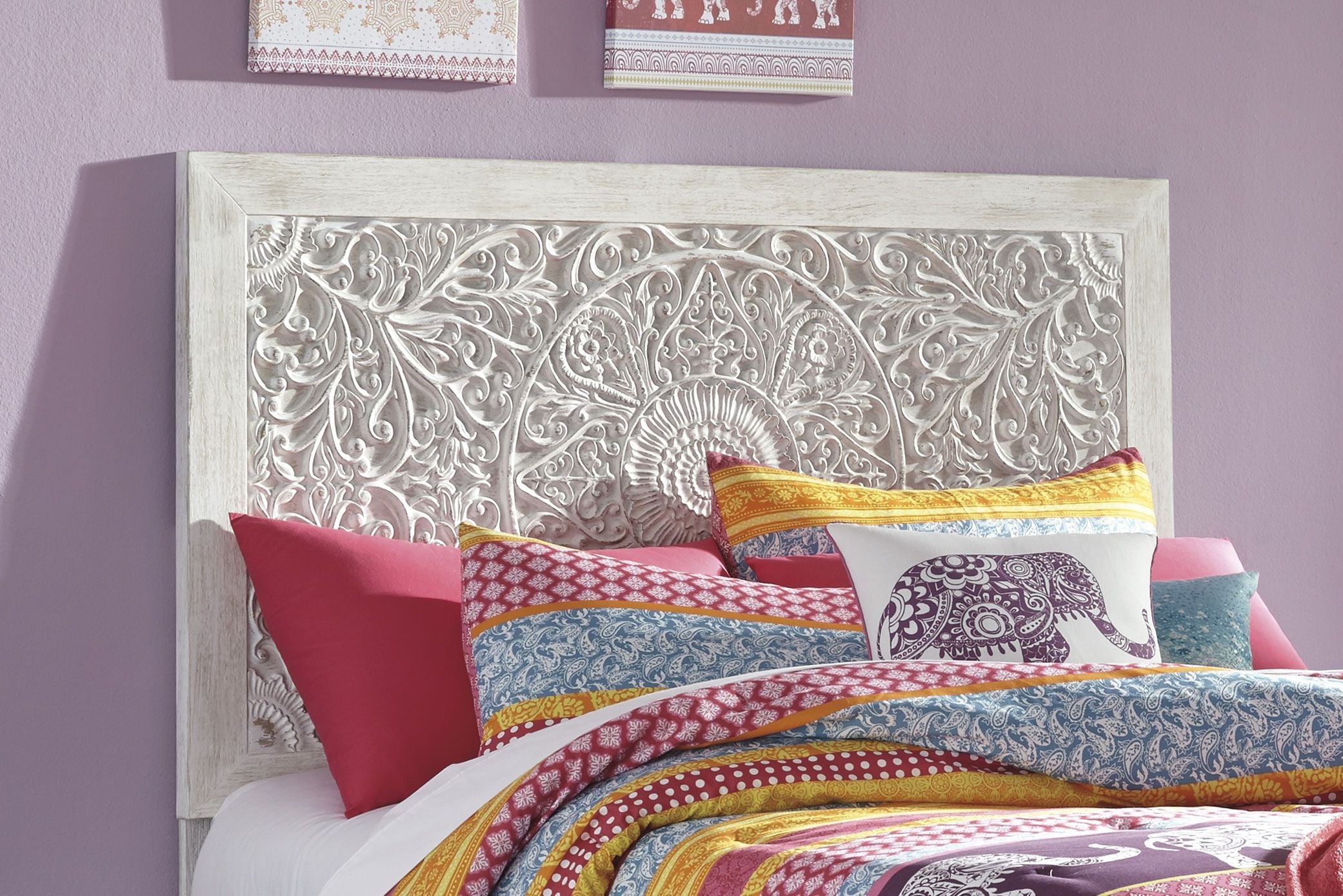 White carved panel headboard with ornate floral scrollwork and circular center medallion