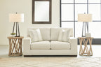 Cream loveseat with two-seat back cushions and two striped throw pillows