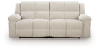 Light beige 2-seat reclining sofa with button-tufted seat cushions and rounded arms