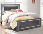 Gray bed with dark headboard and storage drawers, quilt and pillows on top
