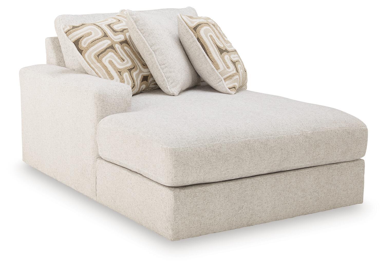Light beige corner chaise with track arms and two patterned throw pillows