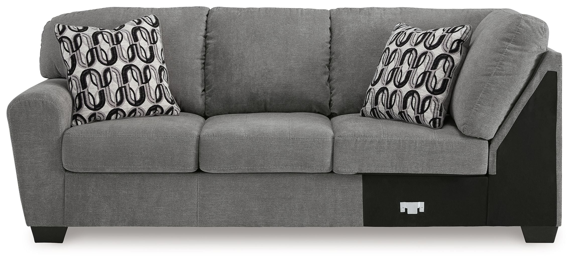 Gray sofa with corner wedge and three back cushions, two patterned pillows