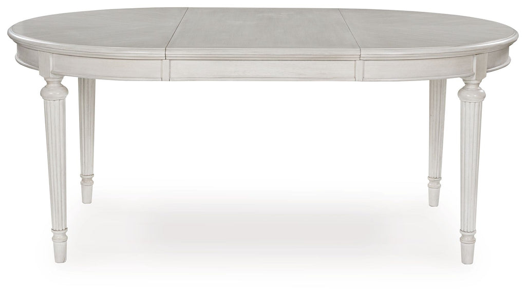 Antique white oval dining extension table shown from the side with center seam