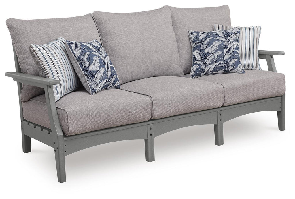 Gray outdoor sofa with cushions and striped floral throw pillows