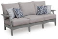 Gray outdoor sofa with cushions and striped floral throw pillows